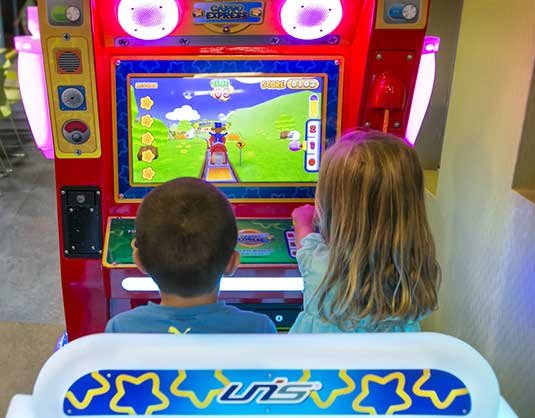 Two children playing an arcade game together, Allstars Indoor Playland Edmonton