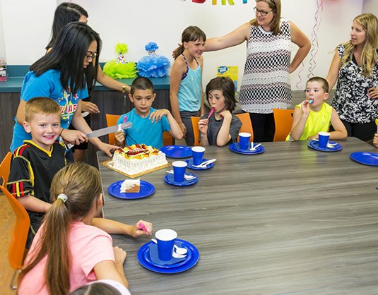 Children and adults gathered around a table with birthday cake, Allstars Indoor Playland Edmonton