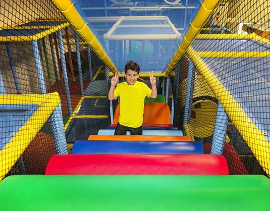 Child playing on a colorful indoor playground climbing structure, Allstars Indoor Playland Edmonton