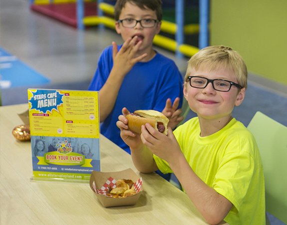 Kids enjoying hot dogs and chips at Star's Café, Allstars Indoor Playland Edmonton